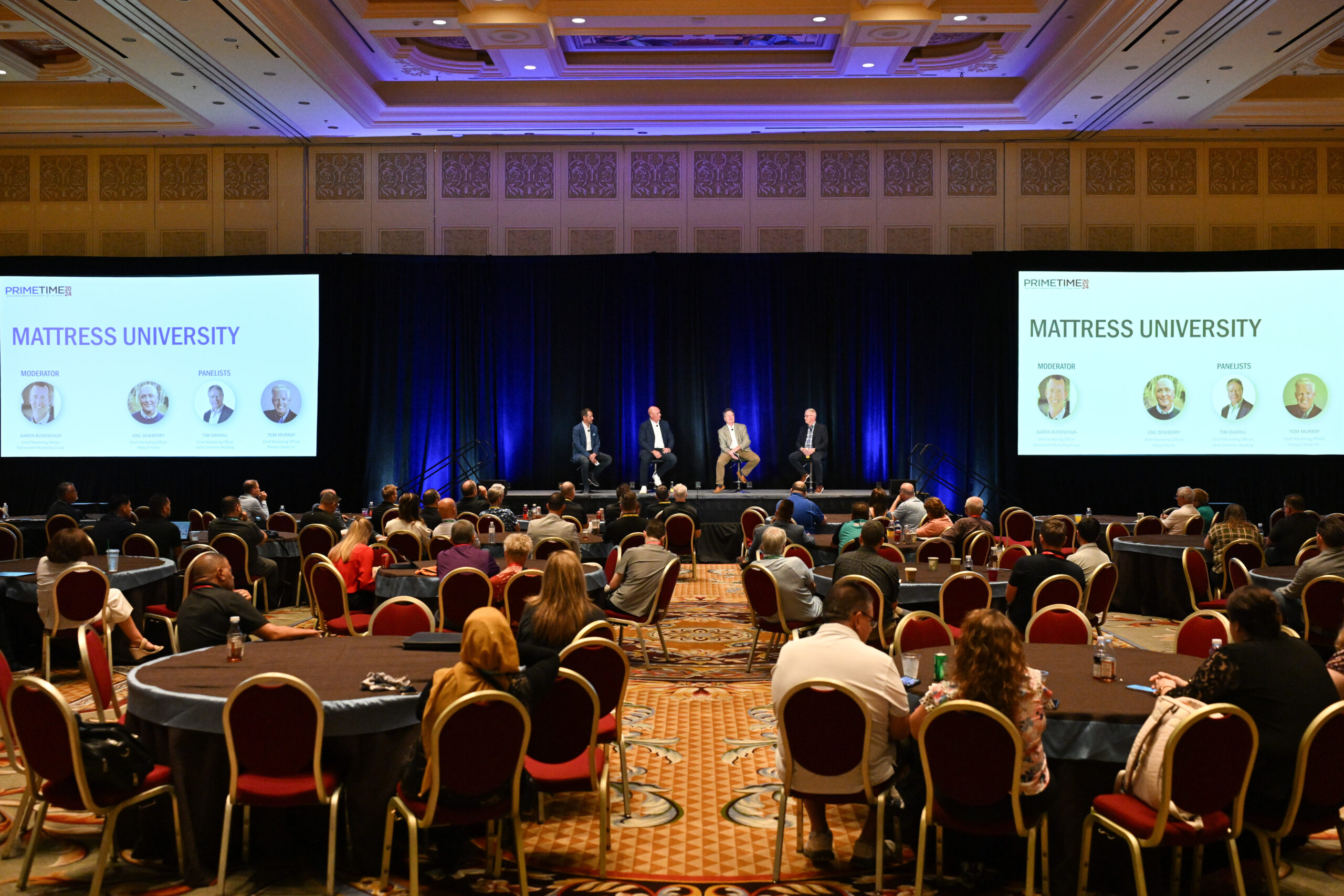 Panel discussion on a stage in a large conference room