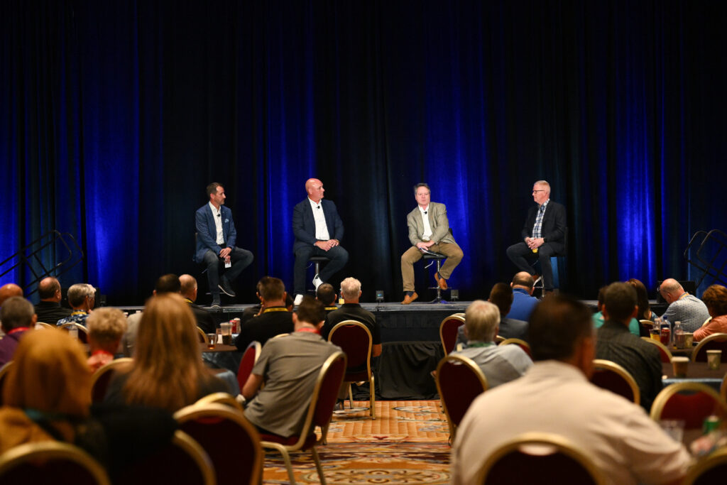 Panel discussion on a stage in a large conference room