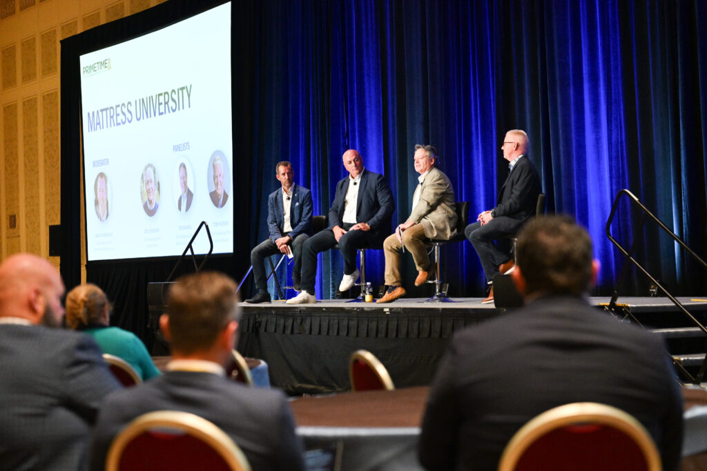 Panel discussion on a stage in a large conference room
