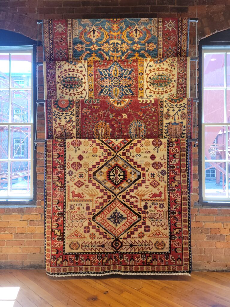 Rugs hanging from the ceiling of a showroom