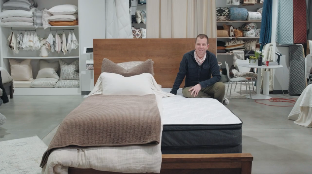 Man sitting on a bed in a showroom