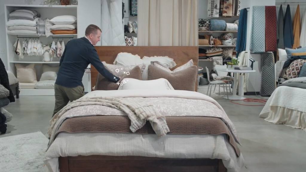 Man making a bed in a furniture showroom