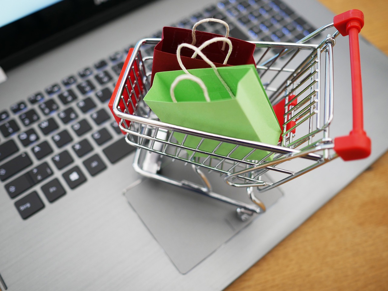 Shopping cart with empty bags on a laptop keyboard