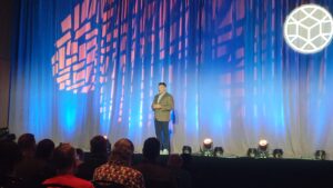 man standing on stage at a convention