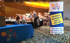 group of people packing meals with No Child Hungry
