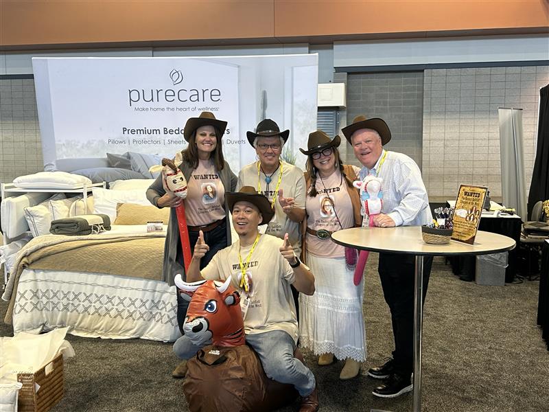 Purecare employees posing at an expo booth