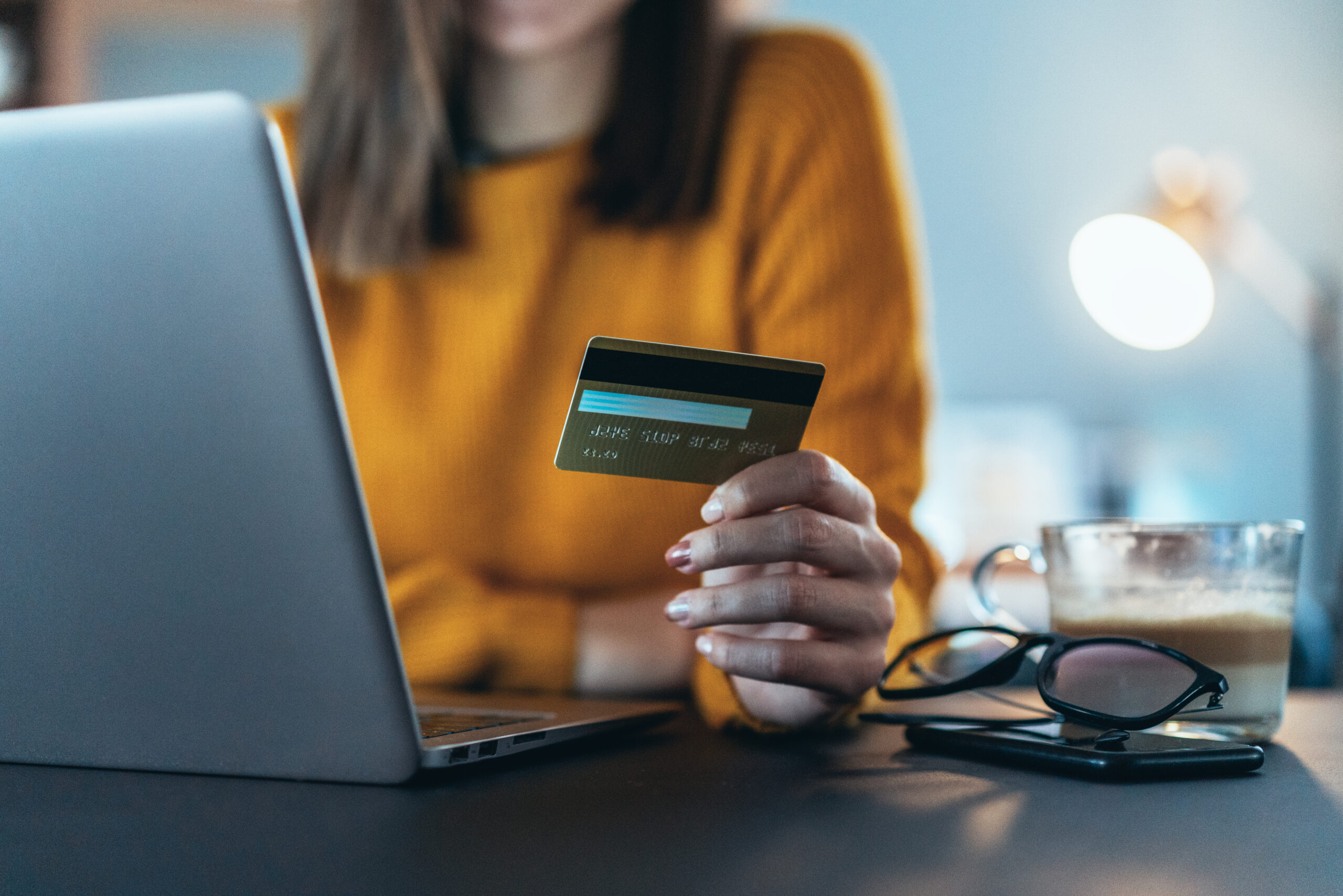 Woman shopping online on a laptop with a credit card
