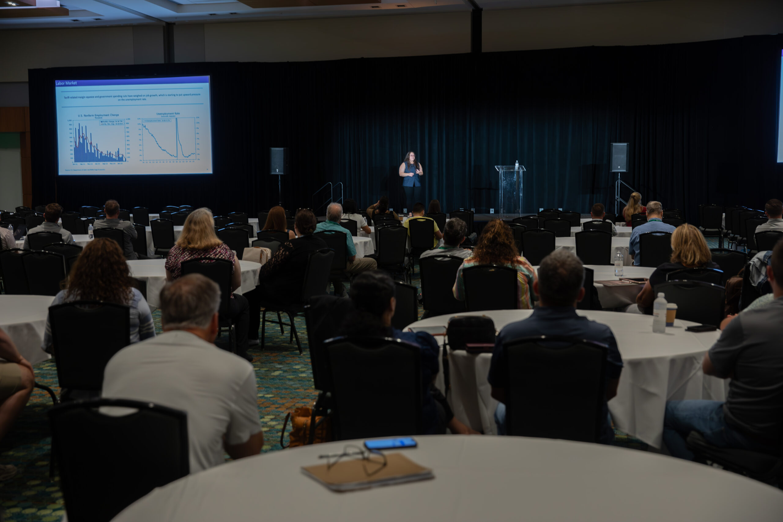 Large room of people attending a conference presentation