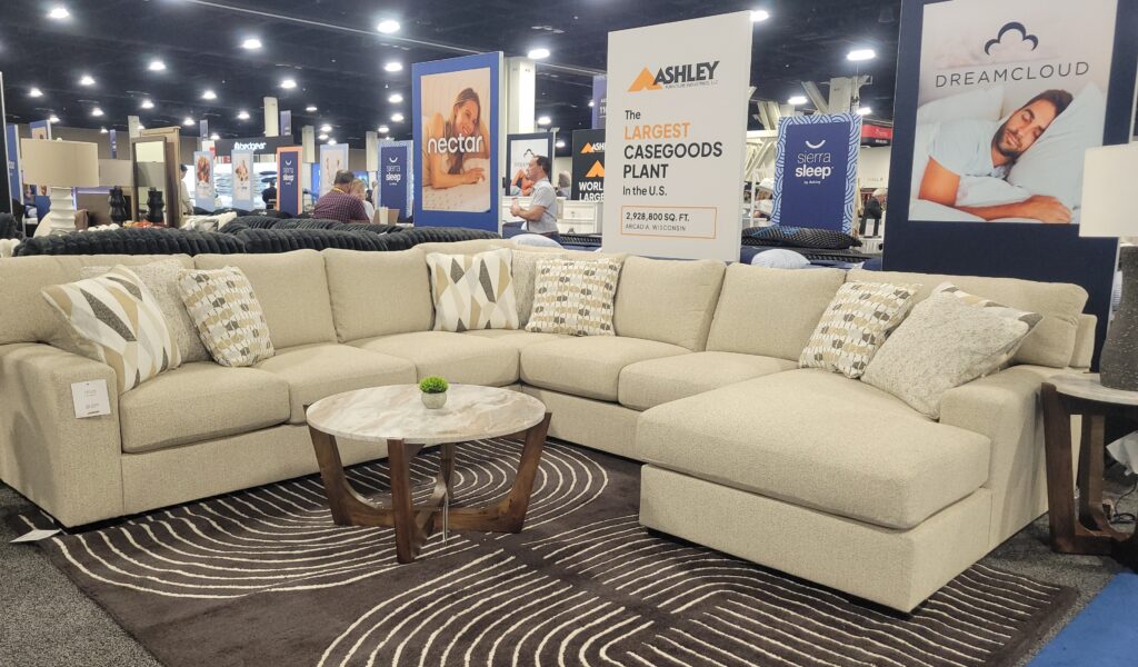 Ashley Furniture neutral sectional sofa displayed at an expo