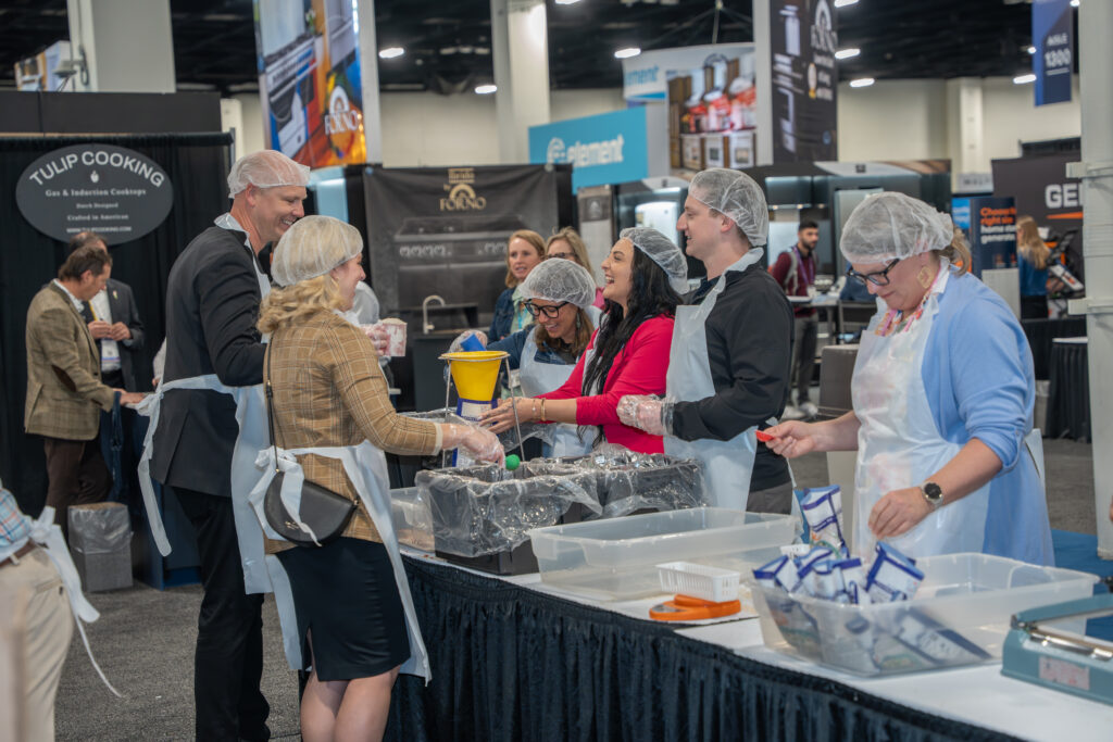 Group of volunteers packing meals at an expo